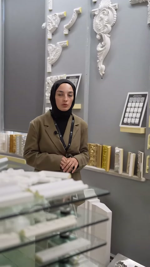 Duvara asılı köşe motifleri ve raftaki numuneler birlikte görülüyor.