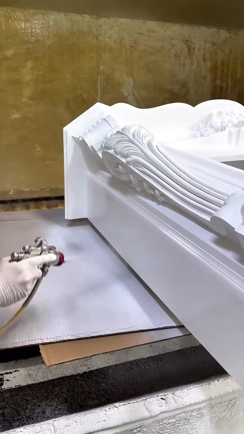 Kabartmalı şömine üst tablasına püskürtme yöntemiyle beyaz boya uygulanıyor