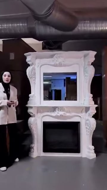 Kabartmalı alınlık ve kıvrımlı ayaklar şömine tasarımını tamamlıyor
