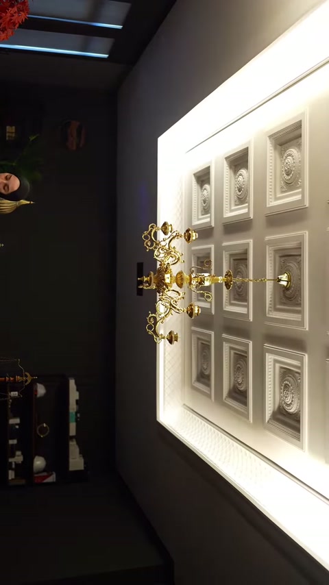 Altın renkli avize, kabartmalı karelerden oluşan dekoratif tavanı tamamlıyor.
