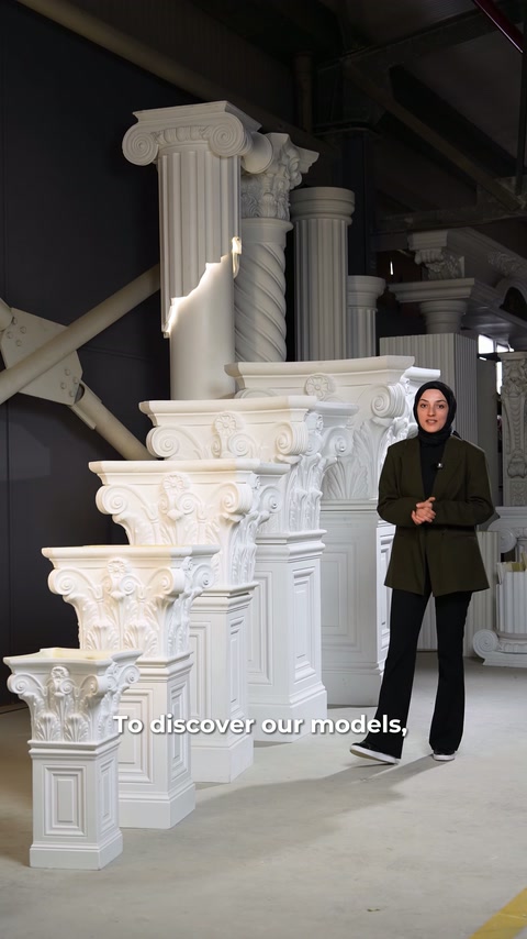 Sunucu, farklı yüksekliklerde dizilen sütun ve başlıkların yanında duruyor.