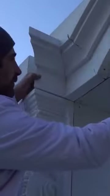 Usta, küçük poliüretan parçayı cephedeki köşe boşluğuna bastırıyor