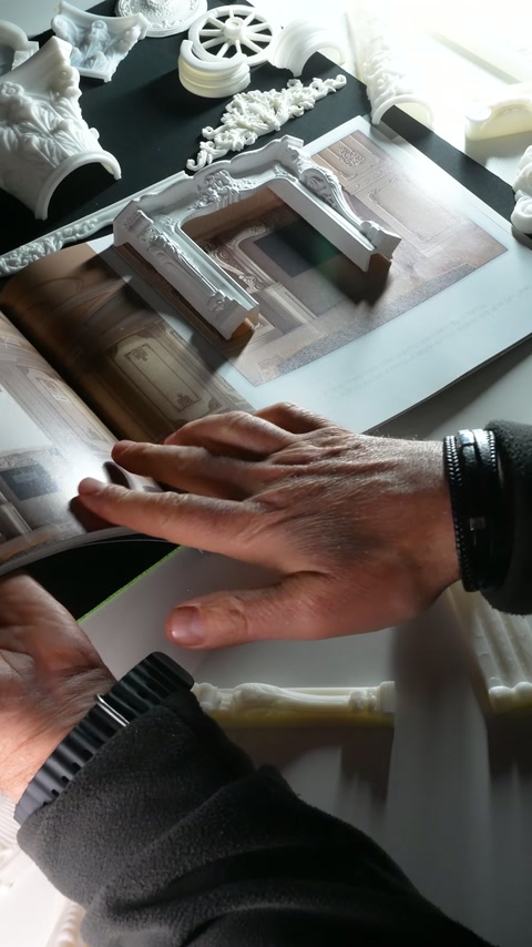 El, beyaz maketin sütunlu yan bölümünü yakından inceliyor