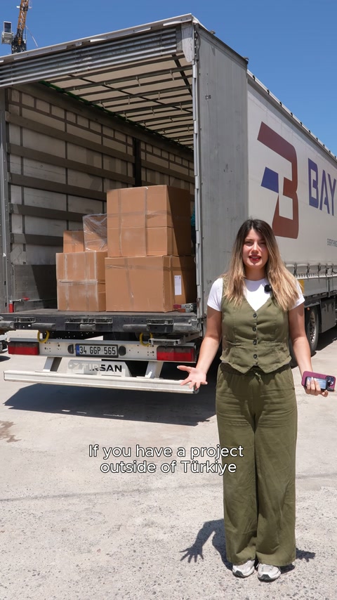 Sunucu, kutularla doldurulan açık sevkiyat aracının önünde konuşuyor