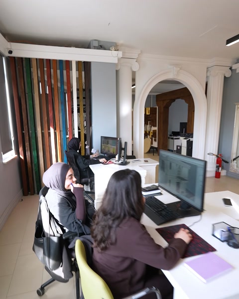 İki tasarımcı ofiste birlikte proje detaylarını görüşüyor