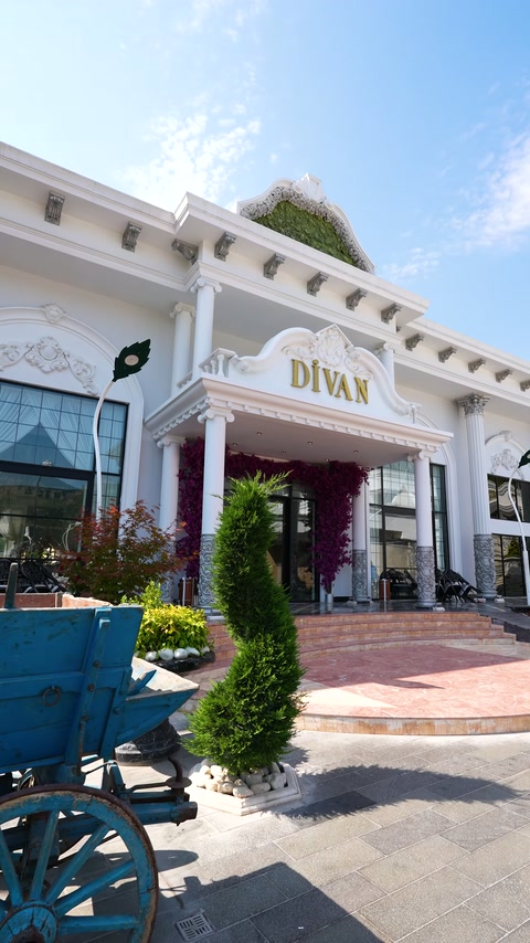 Salon girişinde beyaz sütunlar ile çiçek motifli alınlık birlikte görülüyor.