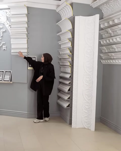 Kartonpiyerlerle çevrelenmiş dekoratif sütun ve tavan uygulaması sergileniyor