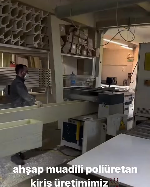 Çalışan uzun poliüretan kiriş profilini üretim makinesinde yönlendiriyor
