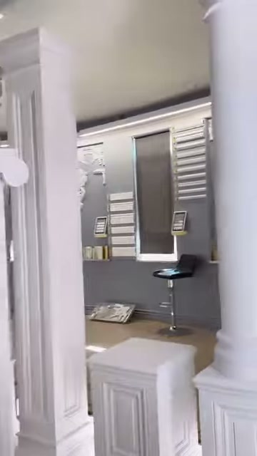 Kademeli başlıklı sade sütun, panelli kaide üzerinde tek başına duruyor.