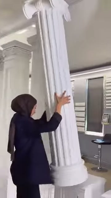 Yuvarlak tabanlı yivli sütun, kıvrımlı üst başlığıyla birlikte gösteriliyor.