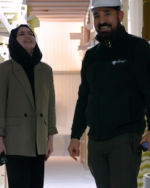 Showroom koridorunda yürüyen iki çalışan