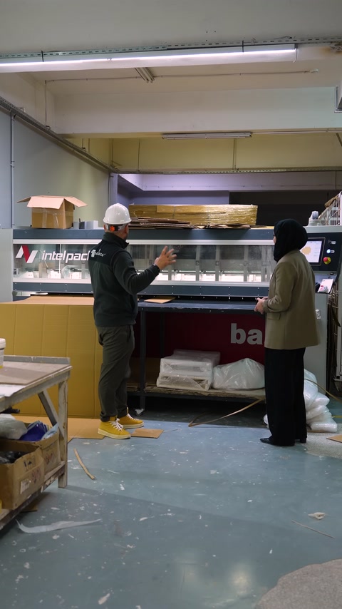 Endüstriyel makine önünde üretim aşamaları hakkında bilgi veriliyor