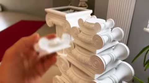Küçük dekoratif parça, volütlü sütun başlığı üzerinde konumlandırılıyor