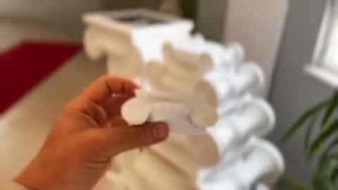 Eldeki kıvrımlı parça, arkadaki volütlü başlıklarla birlikte görülüyor.