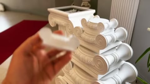 Volütlü sütun başlıkları dizilirken elde başka bir dekor parçası tutuluyor.