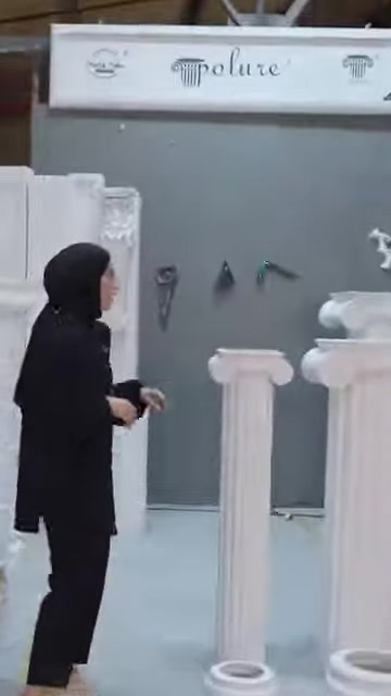 Farklı yüksekliklerdeki beyaz dekoratif sütunlar atölye alanında sergileniyor