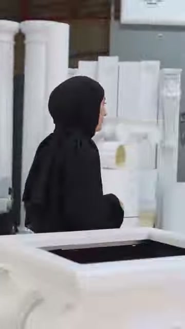 Sunucu, sergi alanındaki kısa sütun modeline doğru yürümeye başlıyor