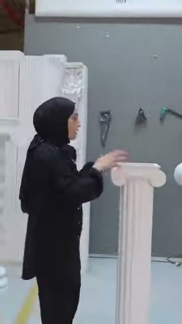 Sunucu, klasik sütun başlığının çıkıntılı üst bölümünü eliyle gösteriyor