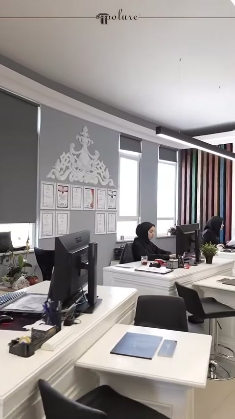 Showroom ofis bölümünde duvar süslemeleri ve beyaz masalar görülüyor
