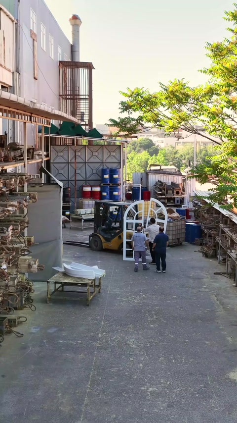 Atölye bahçesinde büyük kemerli pencere modeli dik konumda inceleniyor