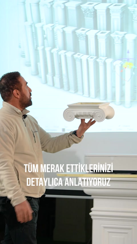 İyonik kıvrımlı beyaz sütun başlığı elde incelenerek sergileniyor.