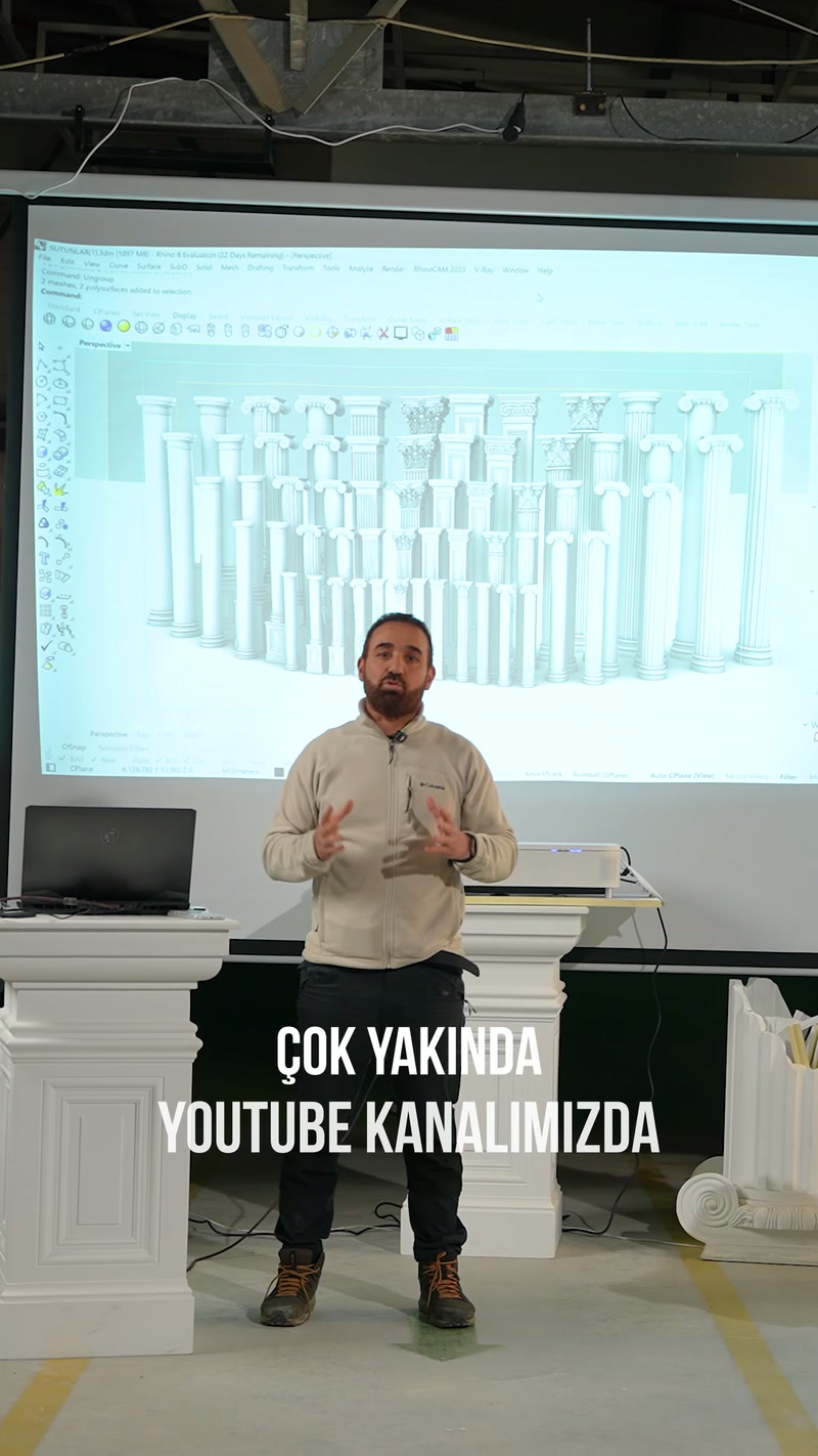 Showroomda sunucu, ekrandaki farklı sütun modellerinin önünde konuşuyor.